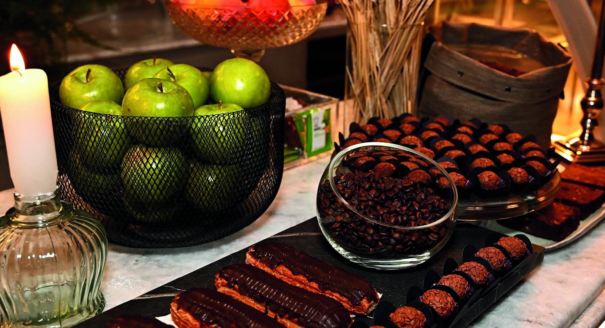 Mesa de café e doces com velas e frutas