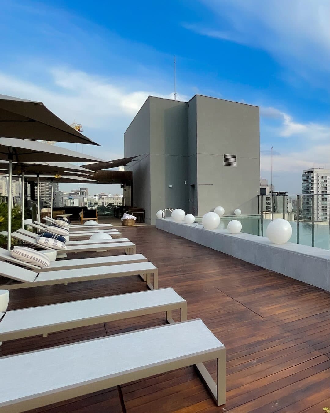 Rooftop com espreguiçadeiras e vista de São Paulo