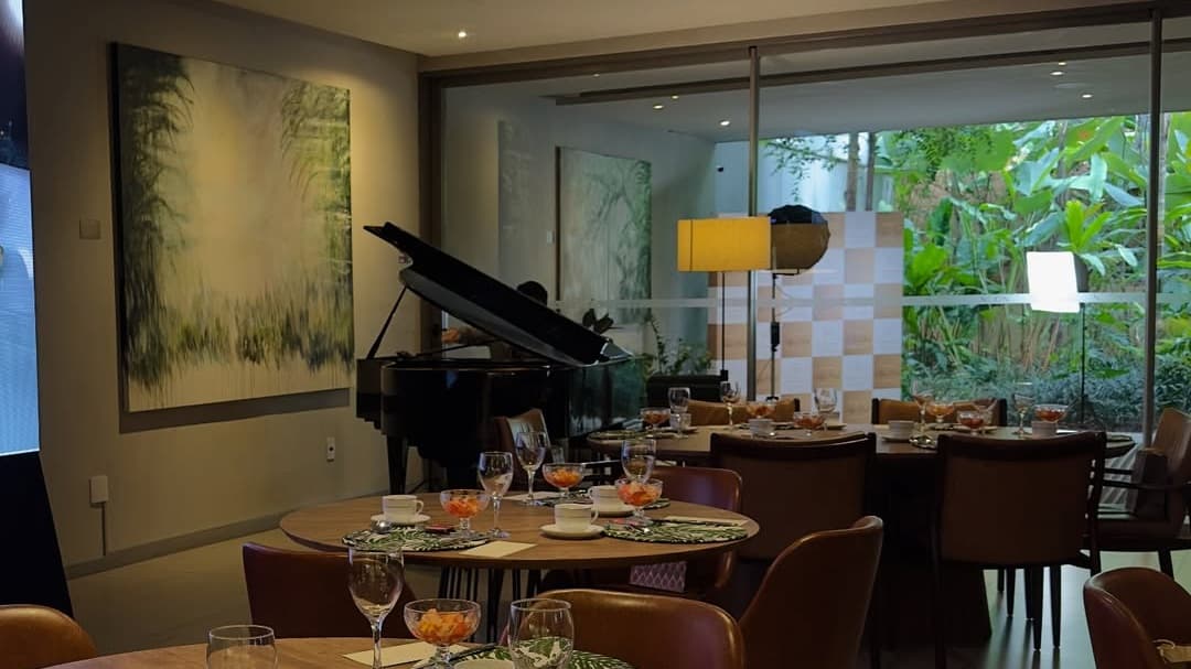 Piano e mesas preparadas em ambiente interno do NOON
